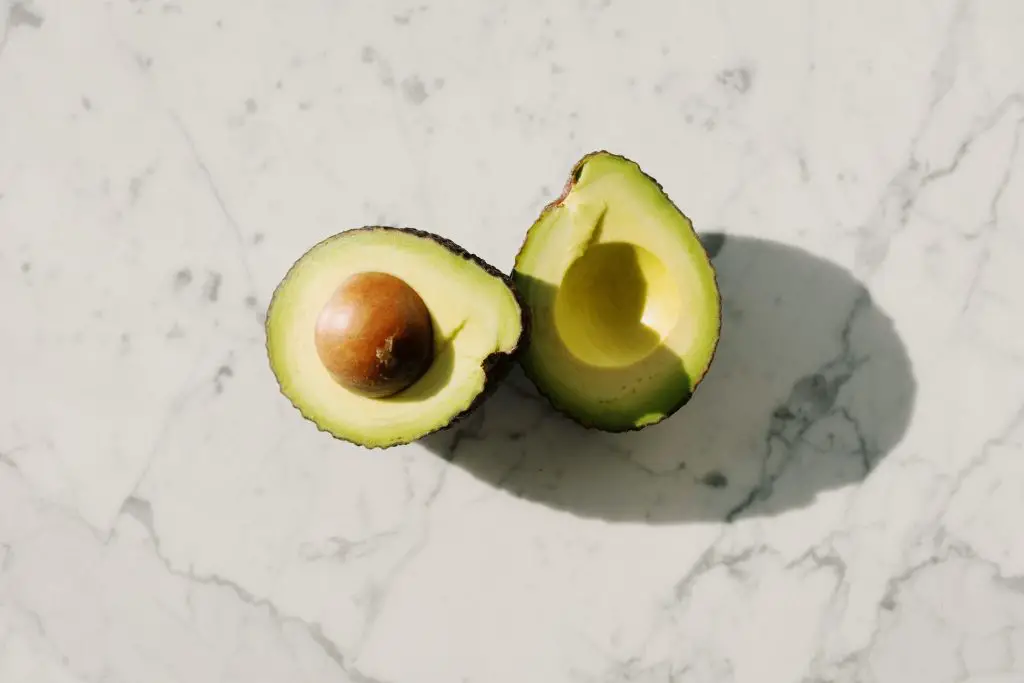 Sliced avocado fruit on white surface